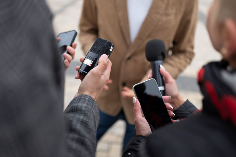 Close up on journalists taking an interview of a man