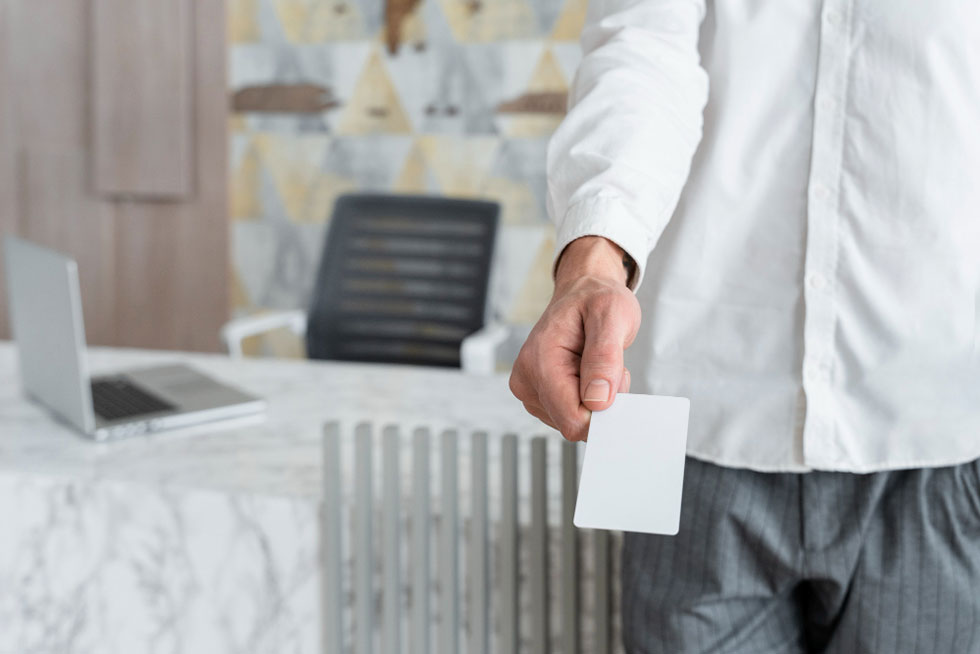 Man pointing card towards camera in office setting