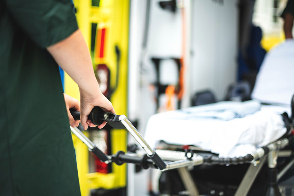 Paramedic pushing stretcher into an ambulance