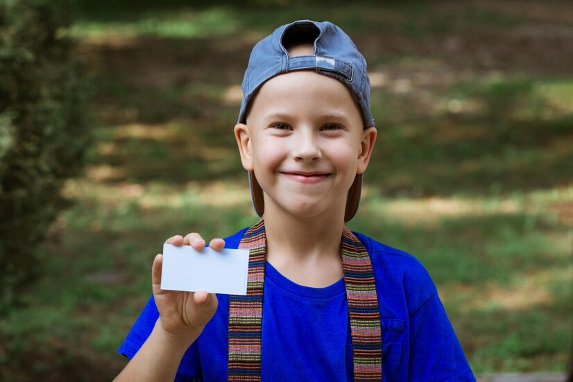 A boy holding his security card at a summer camp