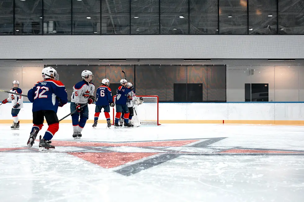 People playing hockey in a sports facility.